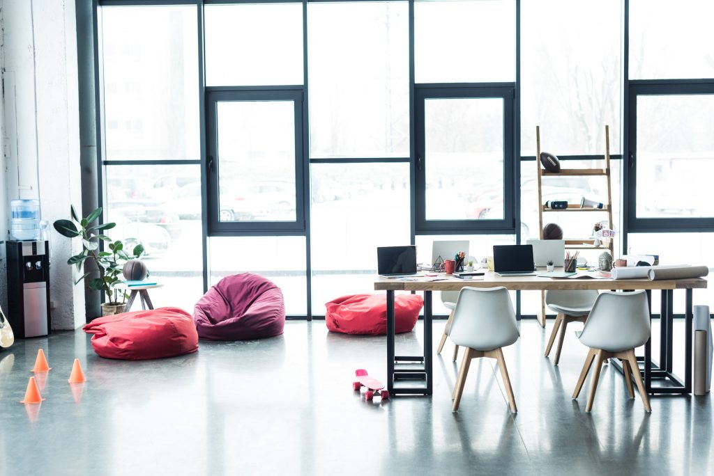 modern design of spacious loft office with bean bag chairs and table with laptops